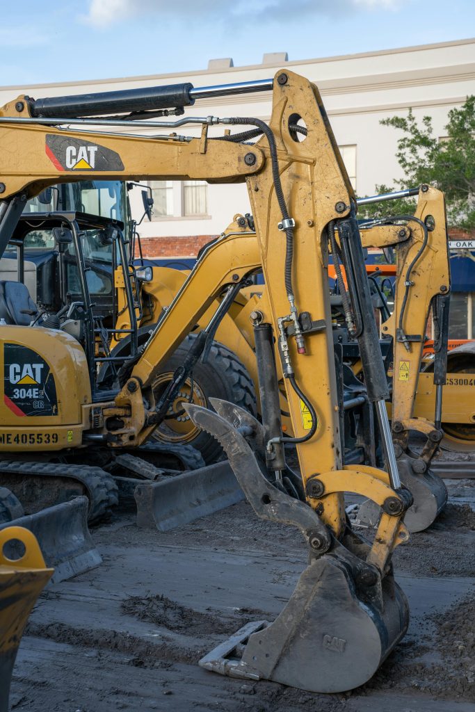 Yellow excavators working at Abu Dhabi construction site with machinery in foreground.